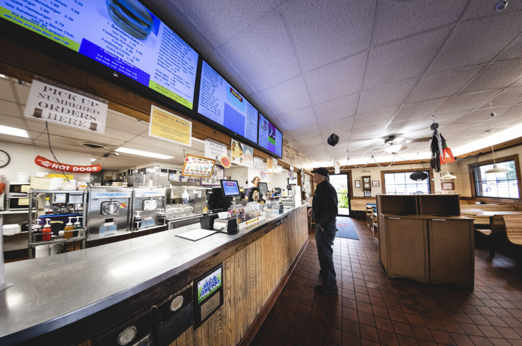 Man standing at the ordering counter at J's Dairy Inn in Liberty, Indiana.