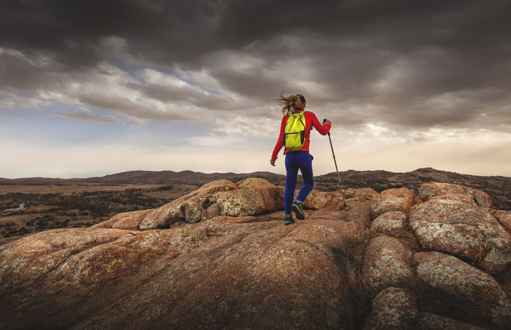 Woman hiker summits Little Baldy in Wichita Mountains Wildlife Refuge, Oklahoma.
