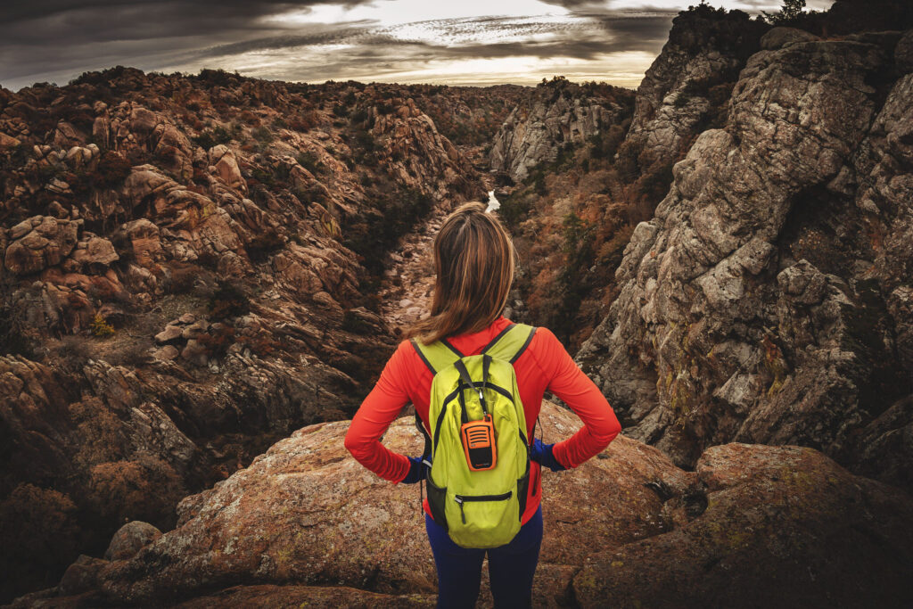 Woman hiker displaying gifts for hikers Zomake backpack PowerTalkie off grid communicator in Wichita Mountains.