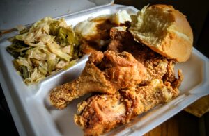Homeboyz fried chicken, cabbage, mashed potatoes and dinner roll in styrofoam container.