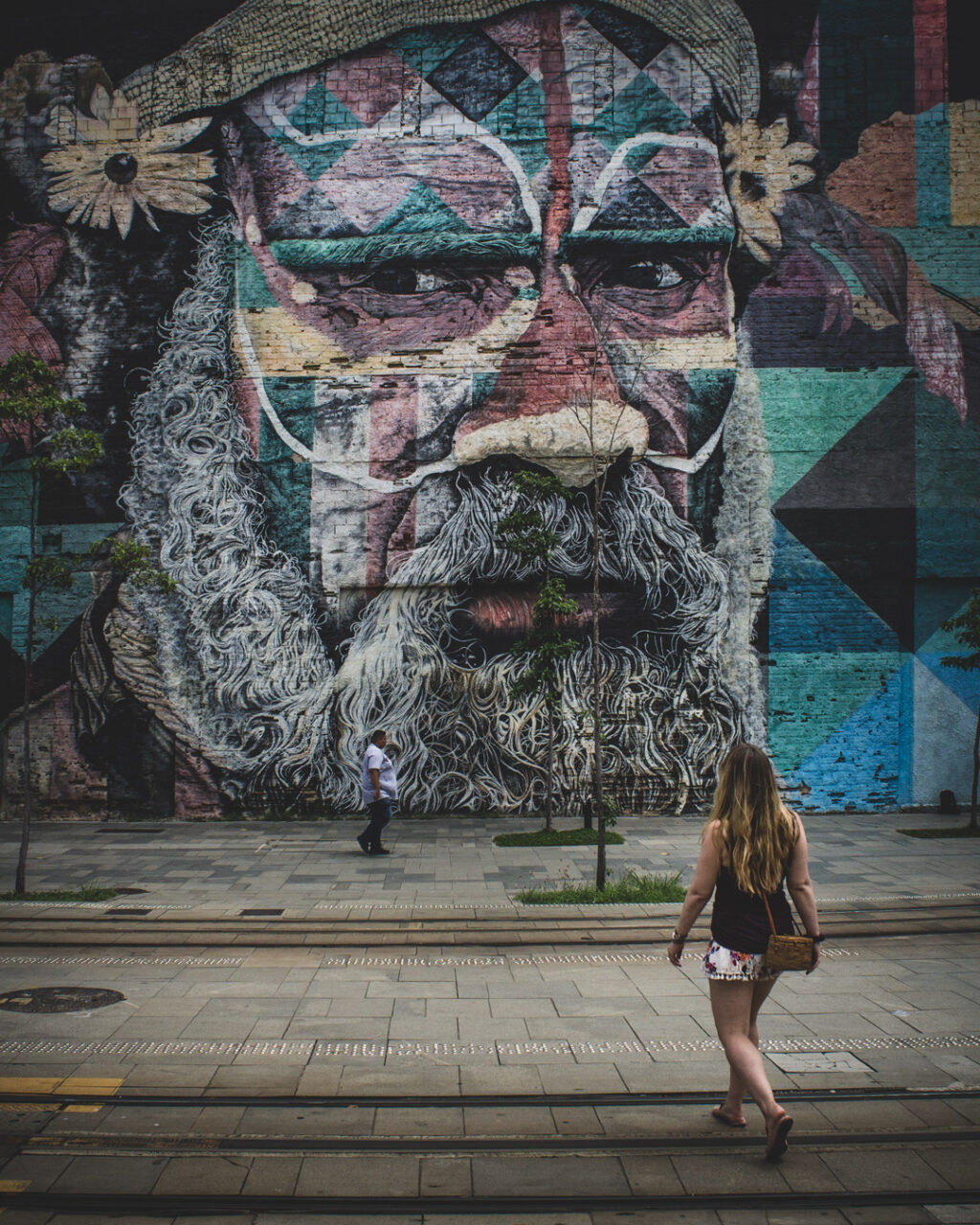 A woman walks toward the Ethnic Groups mural by Eduardo Kobra in Rio de Janeiro, Brazil.
