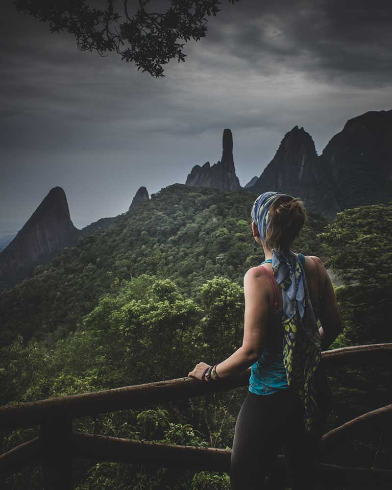 Woman hiker looking Serra dos Órgãos mountains from Mirante Boranda on Trilha 360.