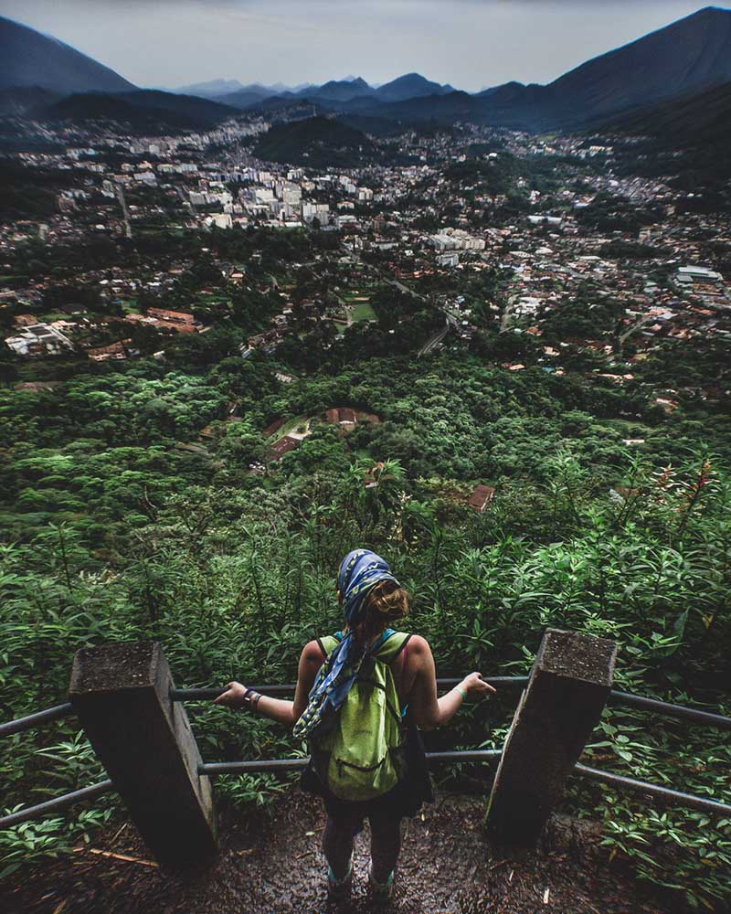 Woman with backpack viewing the city of Teresopolis from the Mozart Catão lookout in Serra dos Órgãos.