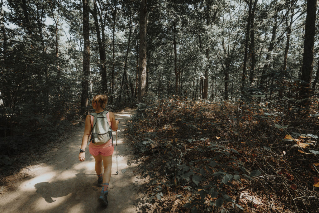 Woman hiking Trail 10 through the woods at Brown County State Park in Indiana.